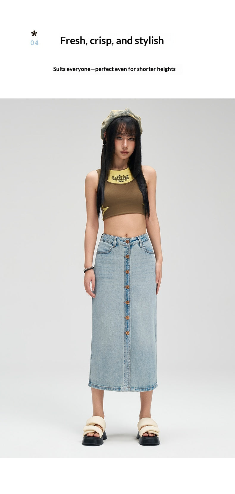 A model stands against a light gray studio background wearing a light-wash denim midi skirt with front buttons, a brown cropped tank top, beige sandals, and a gold necklace. Text at the top reads 'Fresh, crisp, and stylish' and 'Suits everyone—perfect even for shorter heights.