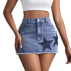 Blue denim skirt with star patches worn by a person on a gray background
