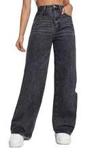 Person wearing high-waisted dark blue jeans on a white background