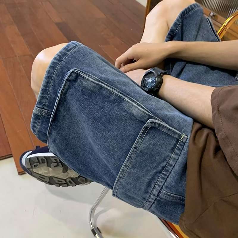 Person wearing blue jeans sitting on a chair with a wooden floor background