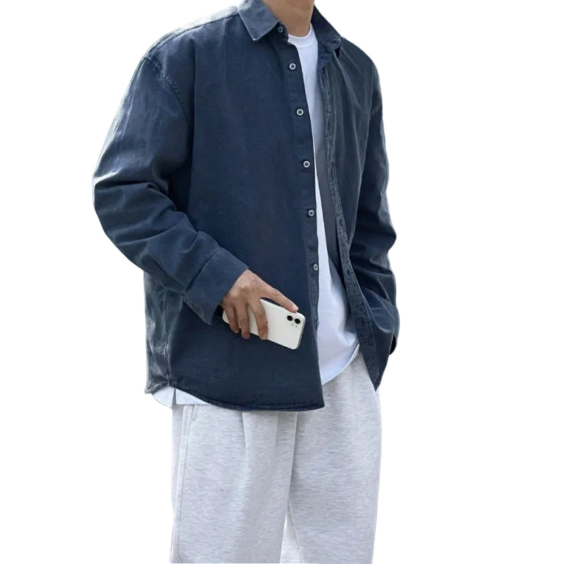 Jeanity Denim – Men's Loose Fit Washed Denim Shirt – JeanityDenimMensLooseFitWashedDenimShirtPersonwearingadarkdenimshirtoverawhiteshirtandlightgraypantsholdingaphonestandingoutdoors20260216125450jpg