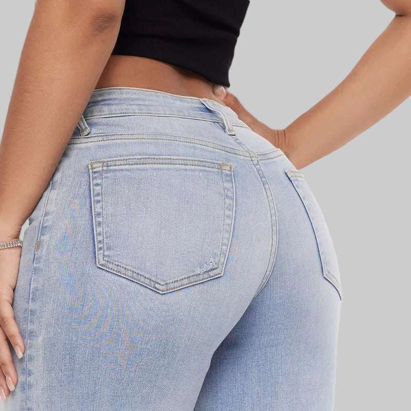 Light blue jeans worn by a person on a plain background